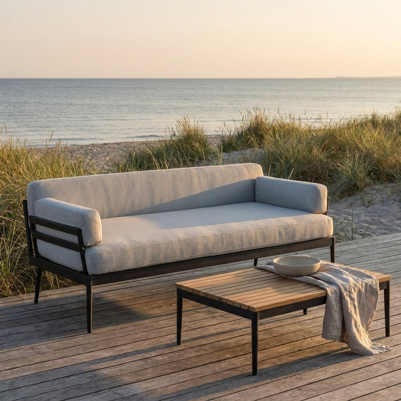 Skargaarden Anholt outdoor sofa and teak lounge table on a seaside deck at golden hour