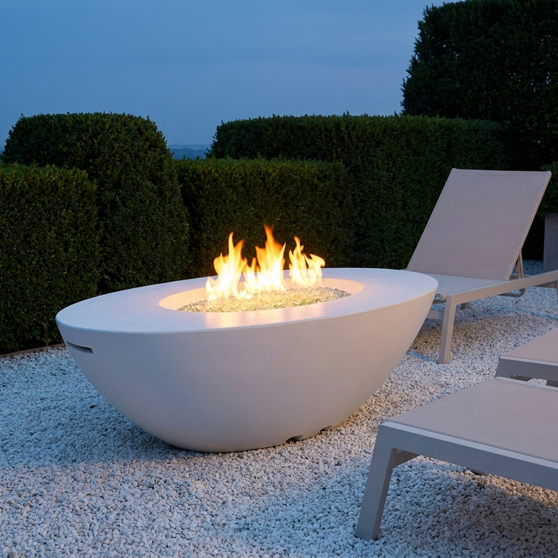 AFD Calais Oval white fire table burning on an elegant terrace at blue hour
