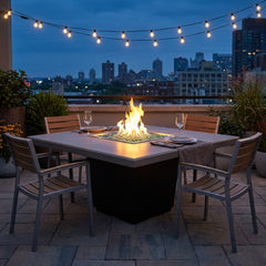 AFD Cosmopolitan Square dining fire table in Smoke finish set for dinner at dusk