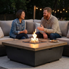 Two friends around the AFD Contempo Square fire table at dusk