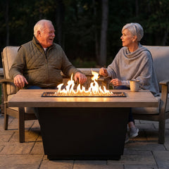 Older couple chatting around the AFD Cosmopolitan Rectangle fire table at dusk