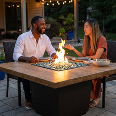 Couple dining at the AFD Reclaimed Wood Cosmopolitan Square fire table at dusk