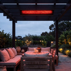 Bromic Platinum Smart-Heat Electric 4500W black panel glowing over a pergola dining nook at dusk