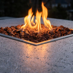 Close-up of flames over lava rock in the Elementi Birmingham dining fire pit table