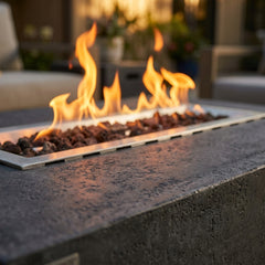 Close-up of flames over lava rock in the Elementi Hampton fire table's stainless steel burner