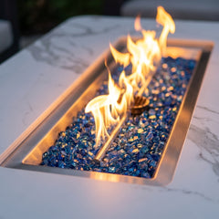 Close-up of flames over Caribbean blue fire glass in the white porcelain Elementi Plus Athens