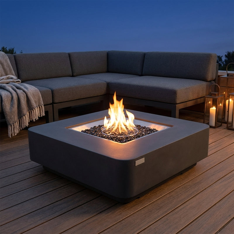 Elementi Plus Bergamo low square dark gray concrete fire pit table with flame on a wood deck at dusk