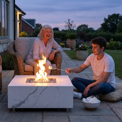 Family toasting marshmallows around the 17-inch-tall Elementi Plus Bianco fire table at dusk