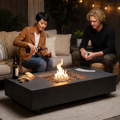 Two friends with wine and cards beside the 14-inch-tall Elementi Plus Cannes fire table at night