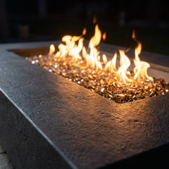 Close-up of flames over bronze fire glass against the gritty sandstone rim of the Positano
