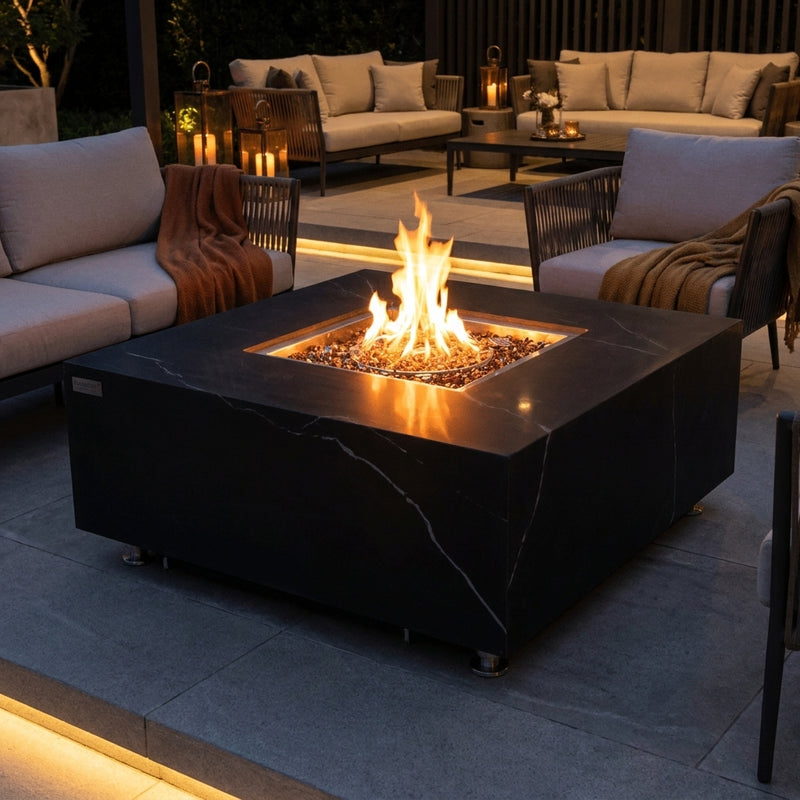 Elementi Plus Sofia black marble-look porcelain fire pit table with flames over bronze fire glass at night