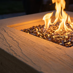 Close-up of flames and sandy striated sandstone texture on the Elementi Plus Uluru fire pit table