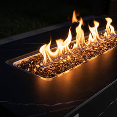 Close-up of flames over bronze fire glass in the black porcelain Valencia