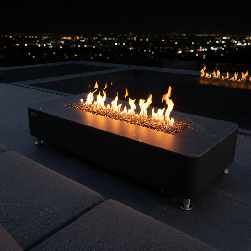 Elementi Plus Valencia long black porcelain fire table lit on a rooftop terrace at night