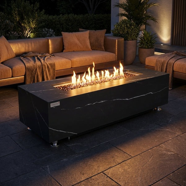 Elementi Plus Varna black marble-look porcelain fire table with flames over bronze fire glass at night