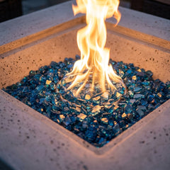 Close-up of the tall round flame over Caribbean blue fire glass in the Elementi Plus Victoria