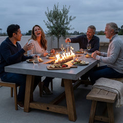 Four people having dinner at the 31-inch-high Elementi Sonoma fire pit dining table at dusk