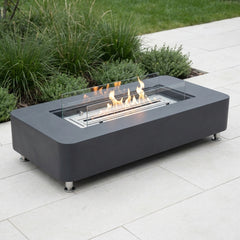 Slate black Elementi Sydney ethanol fire table on a bright patio in neutral daylight