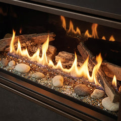 Flame detail: Majestic Echelon II 48 linear direct vent gas fireplace installed in a charcoal media wall, burning at evening