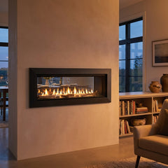 Majestic Echelon II 48 see-through linear gas fireplace installed in a room-dividing wall, burning at evening