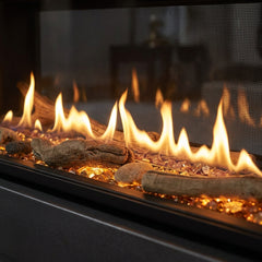 Flame detail: Majestic Echelon II 48 see-through linear gas fireplace installed in a room-dividing wall, burning at evening