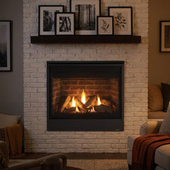 Majestic Quartz 36 direct vent gas fireplace in a whitewashed brick wall, burning at evening