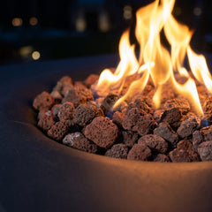 Close-up of flames over lava rock in the round bowl of the Modeno Branford