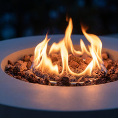 Close-up of the flame ring over lava rock in the Modeno Tramore concrete fire pit table