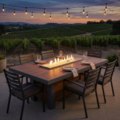 Outdoor Greatroom Kenwood linear dining-height fire pit table set for dinner at dusk