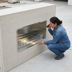 Installer beside the Outdoor Greatroom 40 inch ready-to-finish fireplace enclosure (225 lbs) before cladding