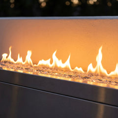 Close-up of the linear flame ribbon over clear fire glass in the Outdoor Greatroom RLFP-72 outdoor fireplace