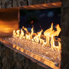 Close-up of the linear flame ribbon over clear fire glass in the Outdoor Greatroom RSTL-72 outdoor fireplace